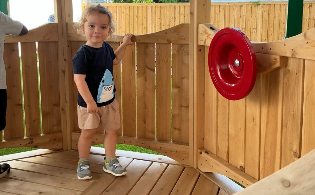Child playing on playground equipment at Montessori school in Houston